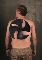 funny man with an electric fan on his back for flying