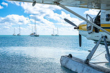 Seaplane floating in the water at Dry Tortugas National Park with distant boats. 
