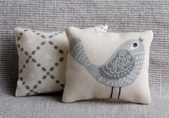 Cushion with bird on gray sofa