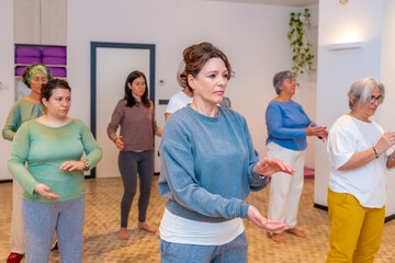 Women moving coordinated join hands in a qi gong class