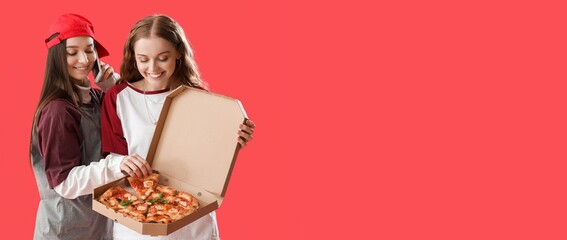Young girls holding tasty pizza in box on red background with space for text
