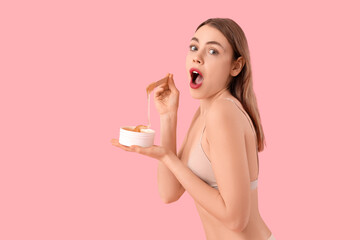 Beautiful young shocked woman holding container with sugaring paste and spatula on pink background