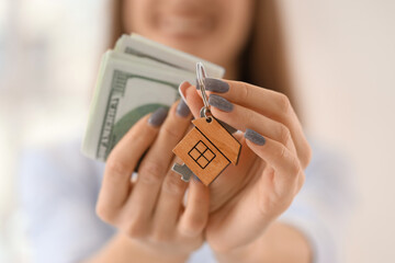 Female real estate agent with keys and money in new apartment, closeup