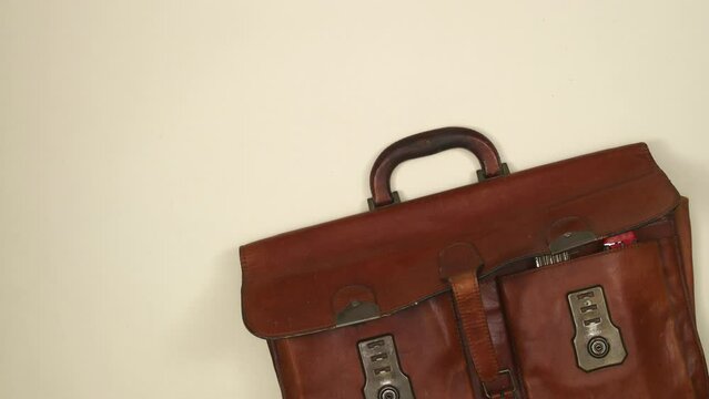 Animated brown leather vintage suitcase with set of tools. Top view, 4K stop motion animation. 