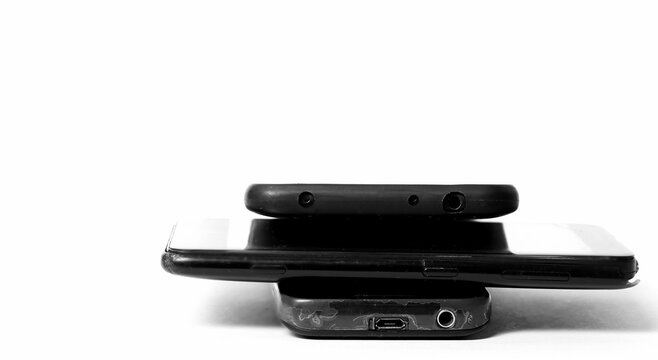 old mobile phones piled up on a table with white background no people stock image stock photo