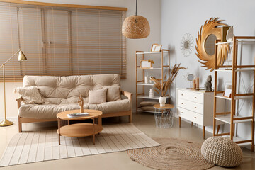 Interior of stylish living room with golden mirror, commode and sofa