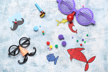 Funny glasses with paper fishes and decor on blue grunge background. April Fools Day