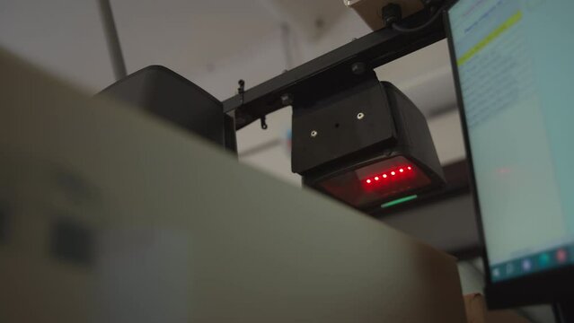 Scanner machine checking the boxes filled with manufactured products at the farm. Modern scanner machine verifying the carton boxes. Scanner machine inspects the boxes on the production line.