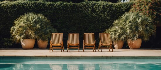 A row of wooden chairs is placed neatly next to a sparkling swimming pool, ready for swimmers to relax and enjoy the water on a sunny day.