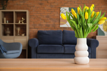 Beautiful tulips in vase on table in living room