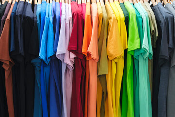 Multicolor family clothes on hangers in store, sale concept background, retail, marketing and...