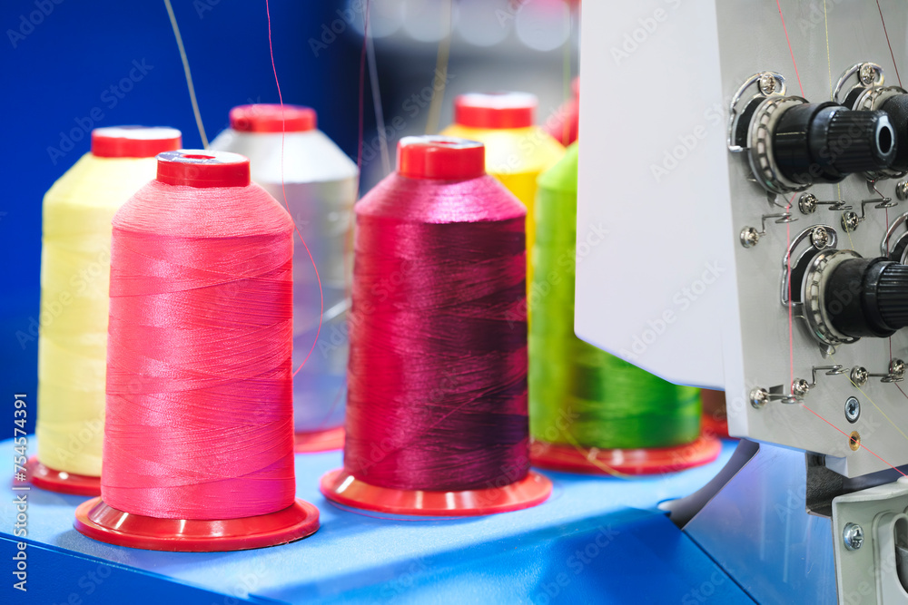 Aufkleber spools of color threads closeup, spinning machine