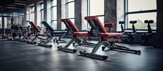 A row of various gym equipment such as treadmills, weight benches, and elliptical machines lined up...