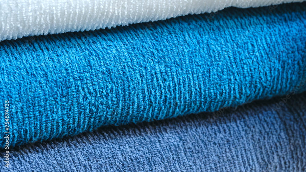 Leinwandbilder multi-colored textile towels lie in a stack on a shelf