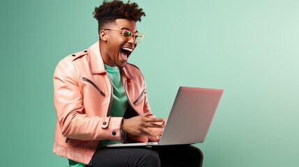 Happy young man looks at a laptop in surprise and joy while working on a solid background