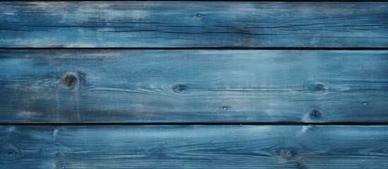 This close-up shot showcases a weathered blue wooden wall, revealing intricate wood grain patterns and textures. The wall is painted in a deep blue color,