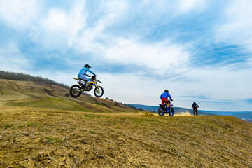 Two motocross riders speeding through an ecoregion on dirt bikes