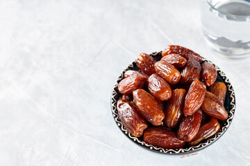 Dates Fruits and Glass of Water on Concrete Background, Ramadan Suhoor Concept, Copy Space