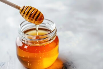 A jar of honey is poured into a spoon. Concept of warmth and sweetness, as honey is often associated with comfort and indulgence