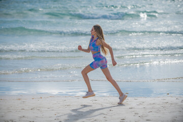 Fototapeta na wymiar Running woman jogging on beach. Fit woman doing workout on sea sand summer beach. Summer sport. Fitness female sport model jog lifestyle. The Running. Fit girl run on beach.