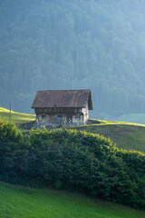 Alps old wooden house. Old House in the European Alps. Old Cabin in the forest. Dilapidated house in the European Alps. Old village houses in a small town in an Alp valley.