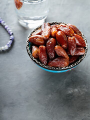 Dried Dates and Water Glass on Gray Concrete, Ramadan Suhoor Concept, Copy Space