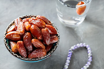 Bowl of Dates and Water on Gray Concrete, Islamic Religion and Ramadan Concept, Close-up