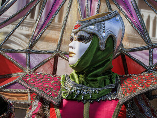  Beautiful female Venetian mask in colorful costume, traditional Venice festival, close-up, face,...