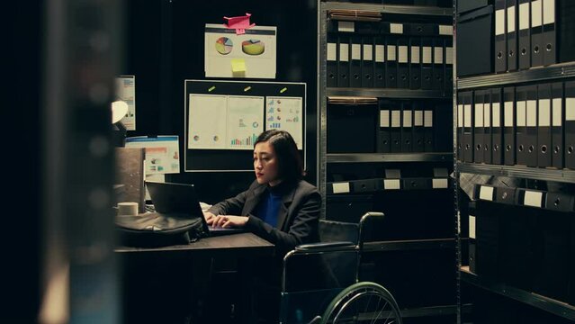 Forensic team extracting DNA samples for modern analysis in archive room, examining criminal evidence and compiles statistical data. Agent with disability working on private investigation. Camera B.