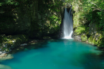 青い池に落ちる滝