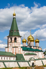 Valday Iversky Monastery, Valday (Valdai), Novgorod region, Russia. View of the monastery wall, bell tower and golden domes of the Cathedral of the Iveron Icon of the Mother of God. Travel in Russia.
