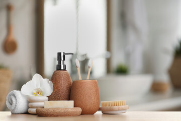 Bath accessories. Different personal care products and flower on wooden table in bathroom, space...