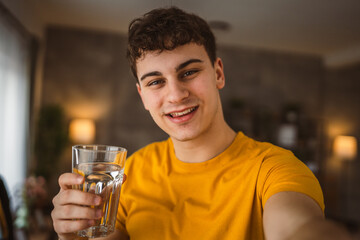 man young caucasian male hold glass of water at home