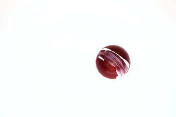 A piece of colored round delicious fancy chocolate on a white background