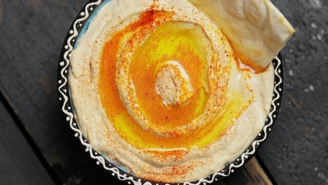 Chickpea Hummus and Pita in Bowl on Dark Boards, Top View