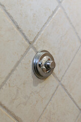 Metal chrome button on the wall in the bathroom, turning the toilet flush on and off, modern...