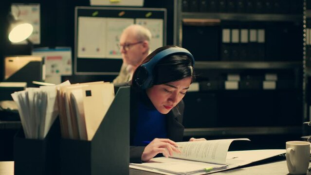 Federal investigator documenting references to forensic evidence, taking notes and rephrasing ideas from legal case files. Law agent recording any insight to uncover new clues. Camera A.