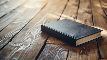 A black hardcover book closed on a rustic wooden table