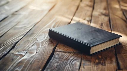 Fototapeten A black hardcover book closed on a rustic wooden table © Татьяна Макарова