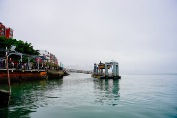 Bali, New Taipei, Taiwan, Republic of China, 01 22 2024: Cruise ferry boat and port on Clean Tamsui river in a raining day in winter