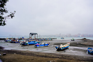Fototapeta premium Bali, New Taipei, Taiwan, Republic of China, 01 22 2024: Cruise ferry boat and port on Clean Tamsui river in a raining day in winter