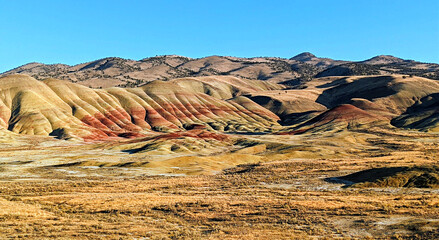 Painted Hills landscape, central Oregon, pumice and ash from volcanic eruptions in the Cascade Mountains traveled 100 miles east and settled over the area. - obrazy, fototapety, plakaty