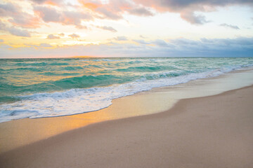 Fototapeta na wymiar Dramatic sunrise horizon, soft sky, turquoise sea waves