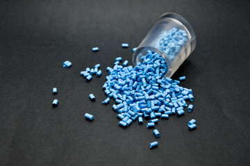 blue masterbatch granules on a black background, this polymer is a coloring agent for products in...