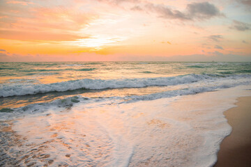 Dramatic sunrise horizon, soft sky, turquoise sea waves