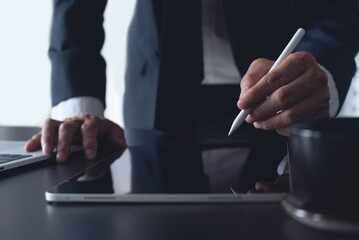 Close up, businessman using stylus pen signing e-document on digital tablet at office, E-signing,...