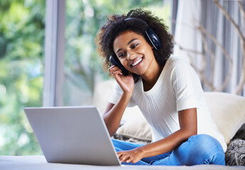 Headphones, woman and laptop at home for online education, e learning and homeschooling in living...