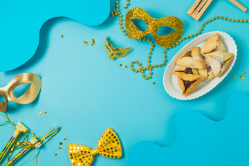 Jewish holiday Purim background with carnival mask and hamantaschen cookies. Top view, flat lay ...