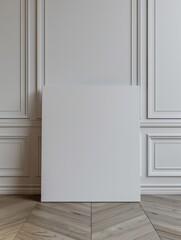 A blank canvas model leans against the white walls of a modern minimalist wood floor. 