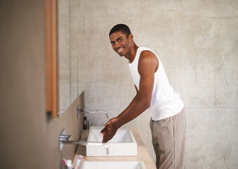 Bathroom, sink and black man washing of hands, portrait and smile for cleaning with water from tap....